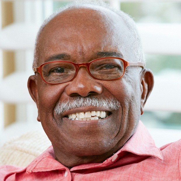Smiling elderly man sitting indoors