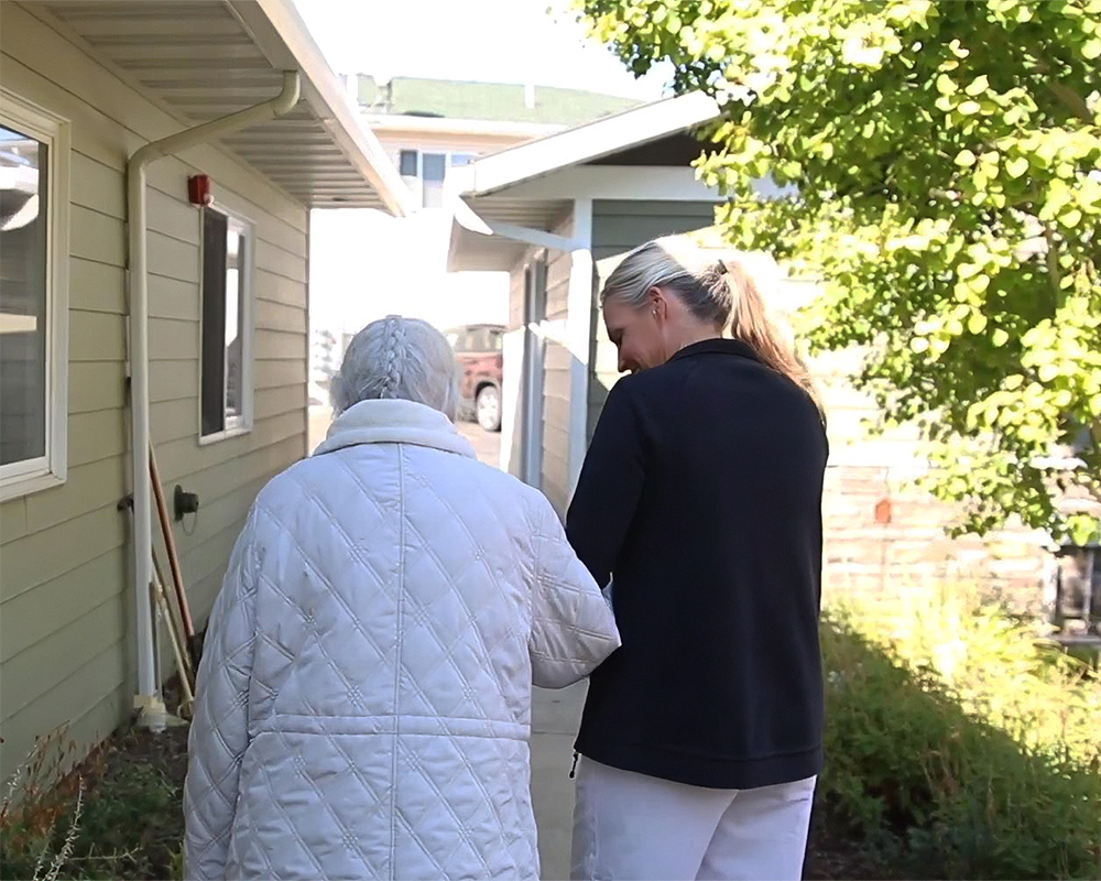 Staff assisting a resident outdoors in the garden