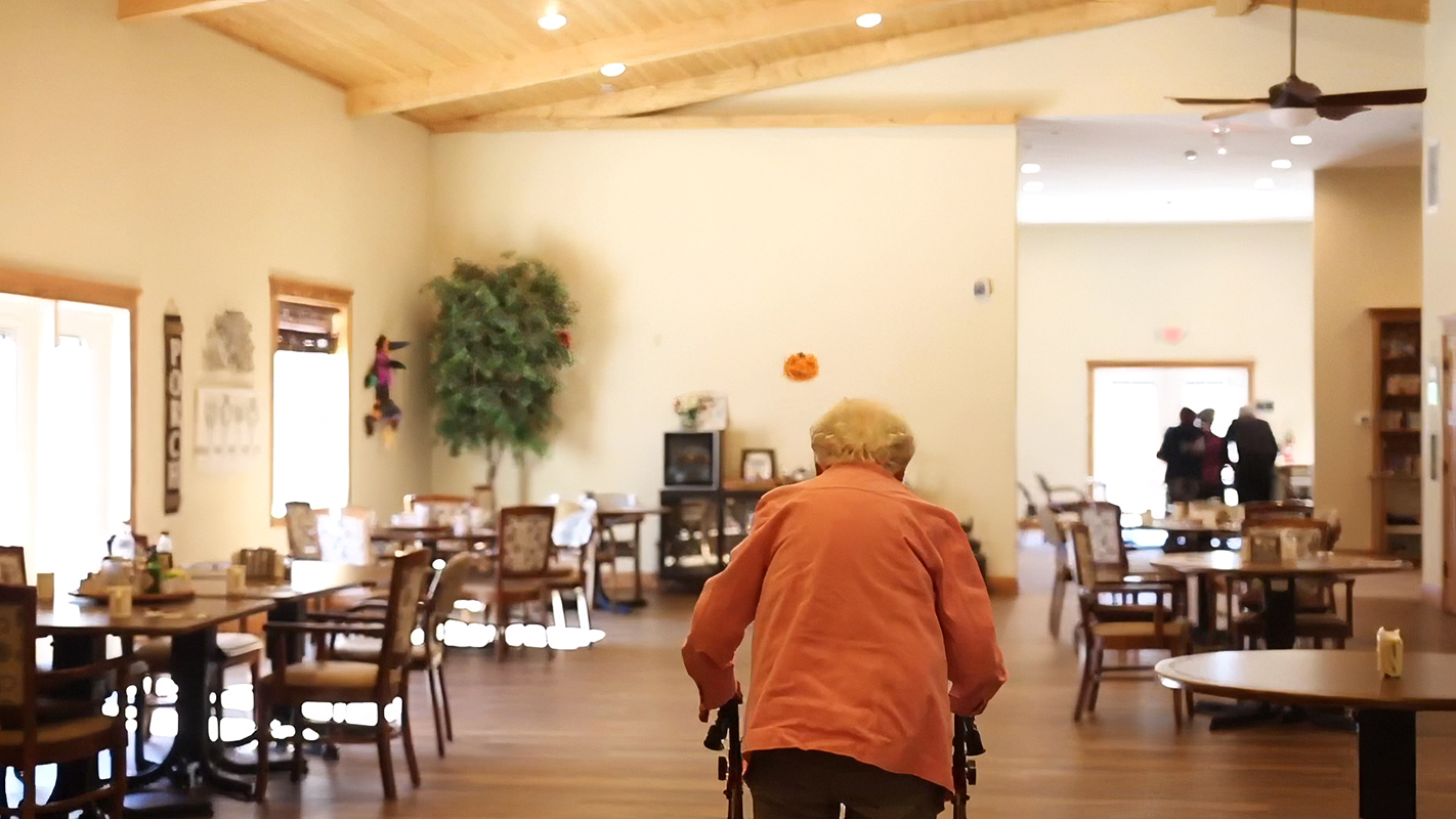 Resident walking with walker in a common area