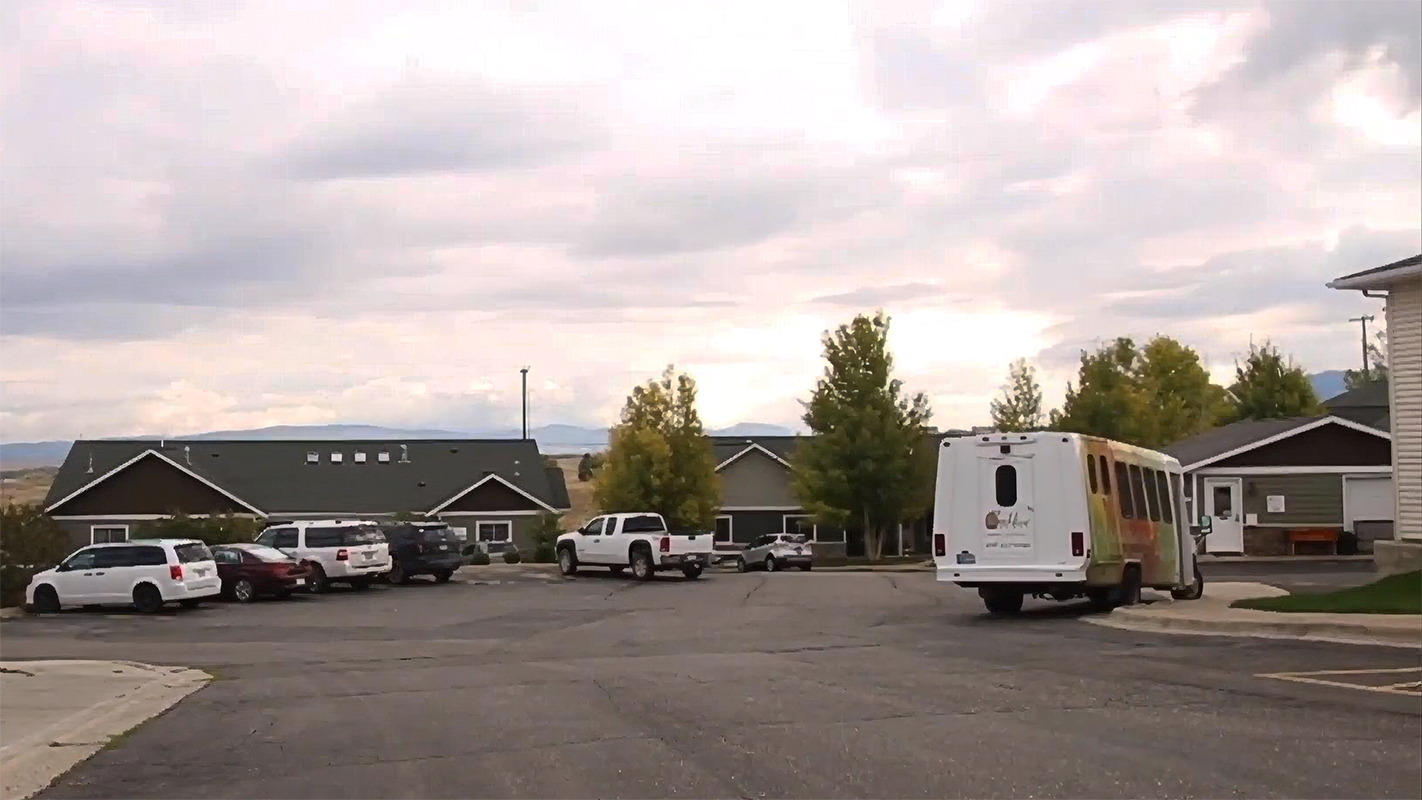 Parking lot with facility transport vehicles and buildings in view
