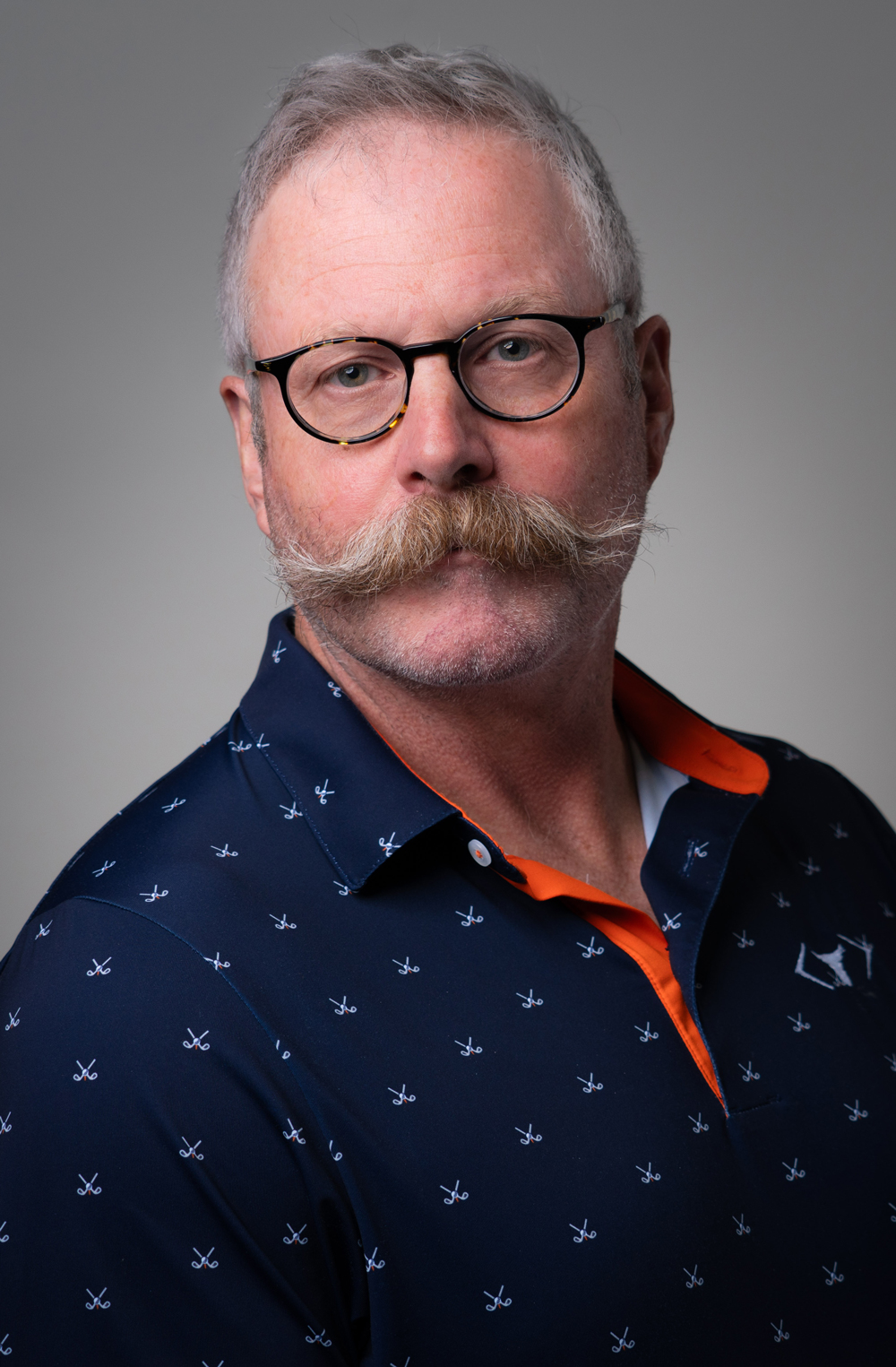 Portrait of a man with a mustache wearing glasses