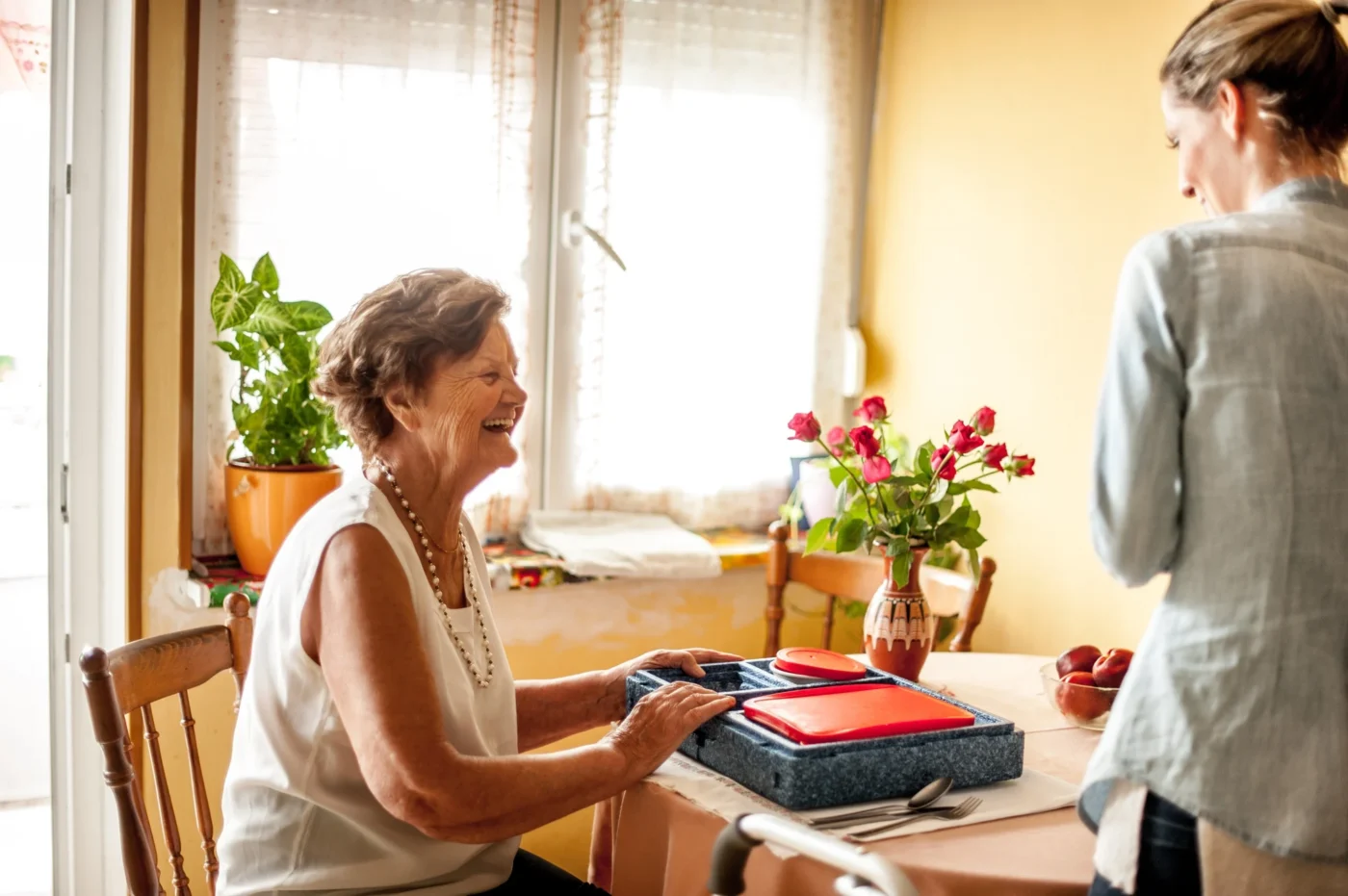 A smiling resident enjoying a meal in a bright dining area