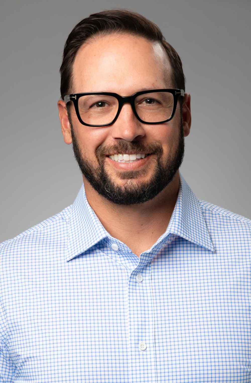 Smiling man wearing glasses and checkered shirt