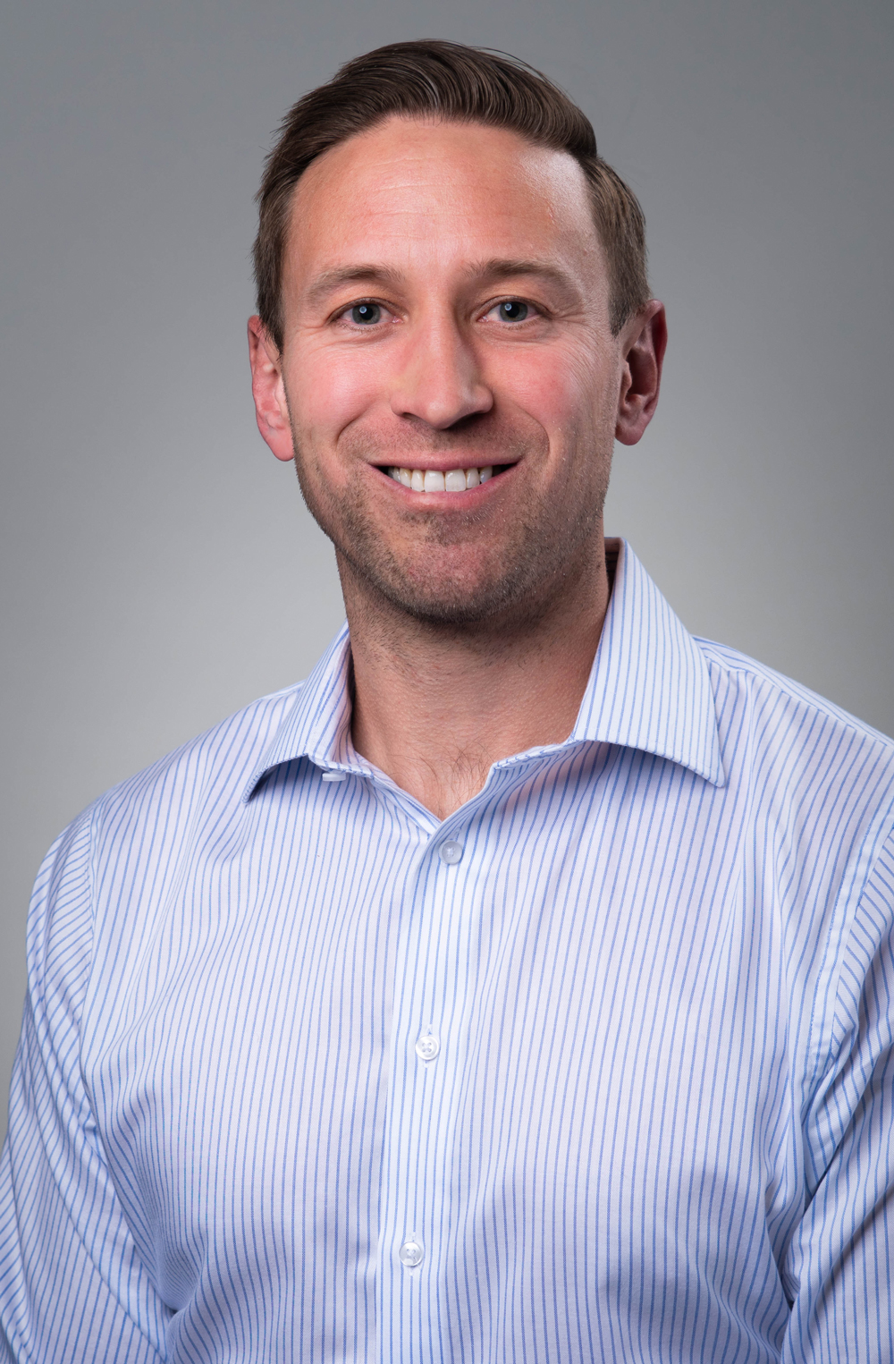 Professional portrait of a smiling man in a striped shirt