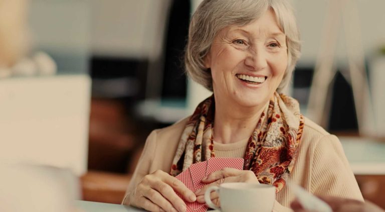 Resident playing cards and enjoying tea in a common space