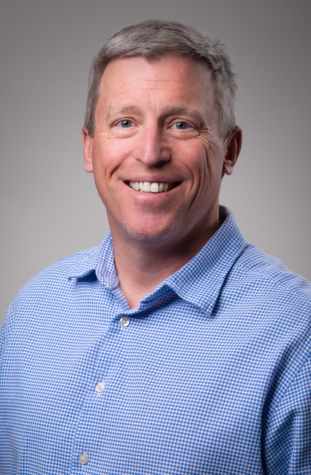 Smiling man in a blue checkered shirt