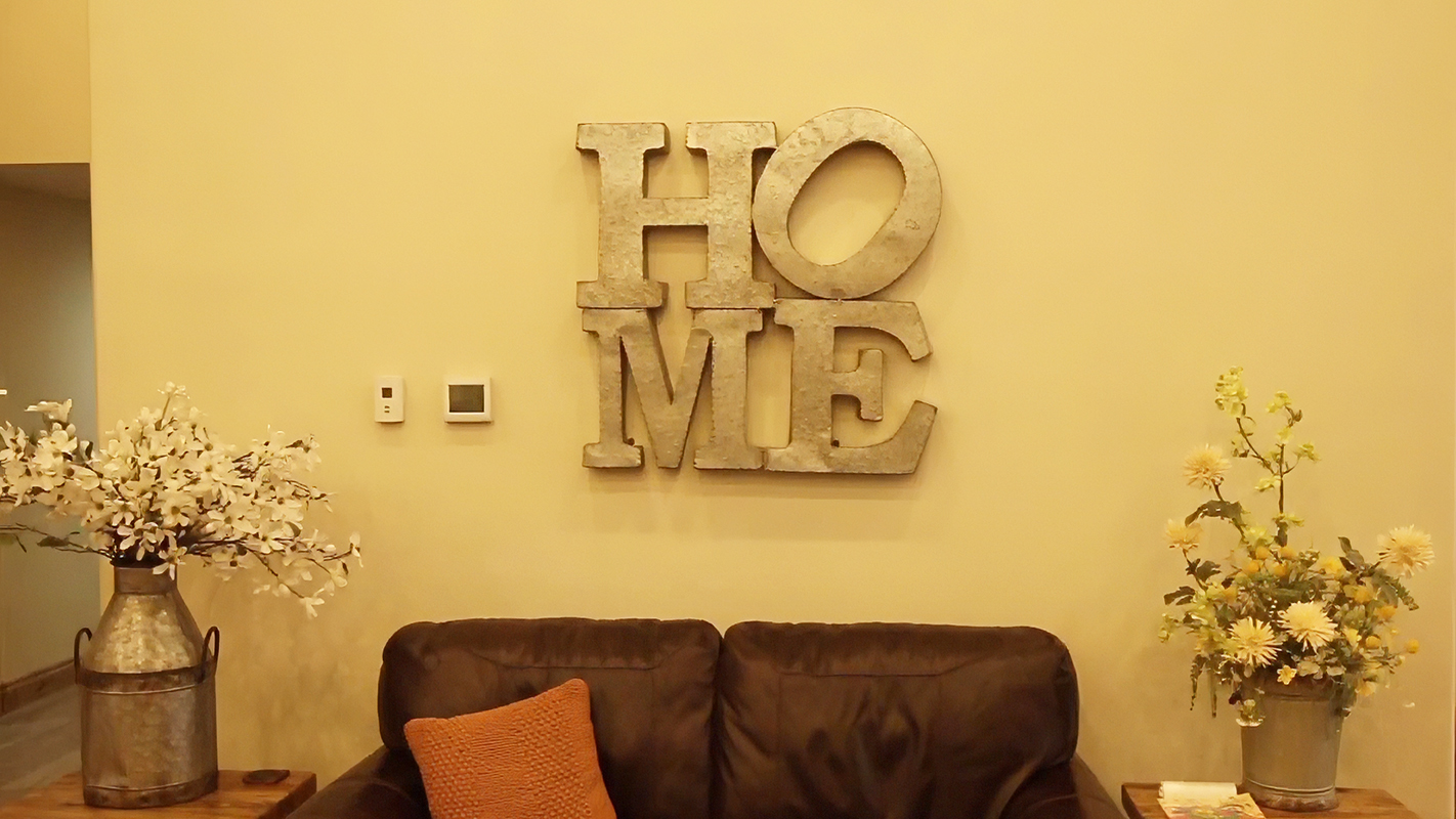 Decorative wall art saying 'HOME' in a cozy interior space