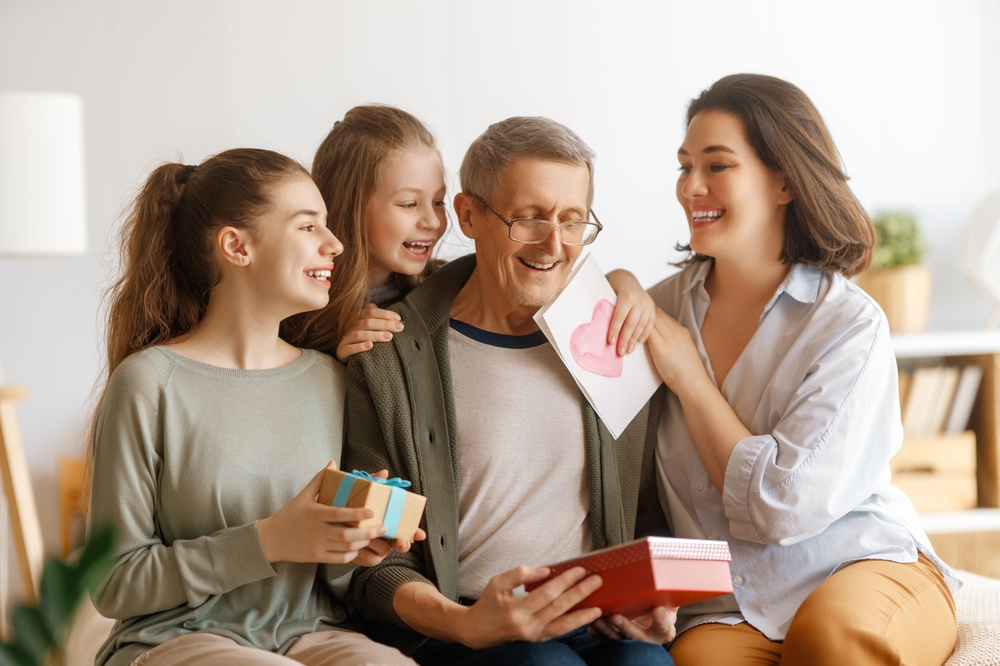 Family celebrating with a senior in a cozy living room