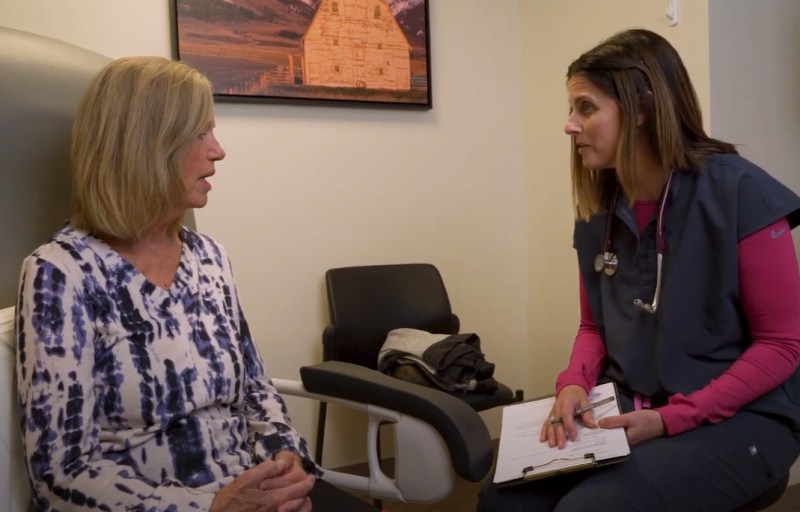 A caregiver interacting with a resident in a well-lit room