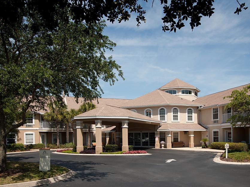 Front entrance of a senior living facility with landscaped surroundings