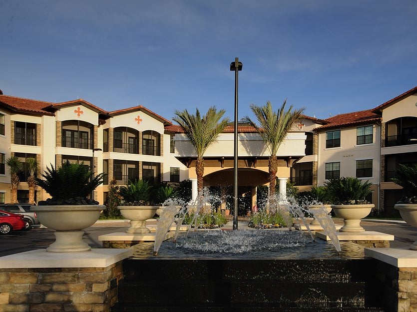 Exterior view of a senior living facility with a fountain