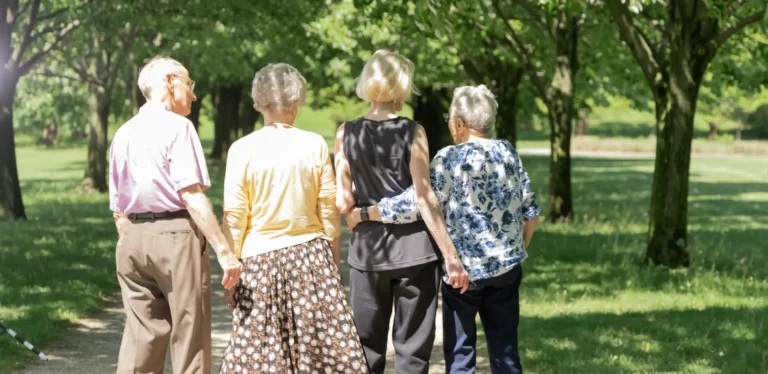 Four residents walking together in a park