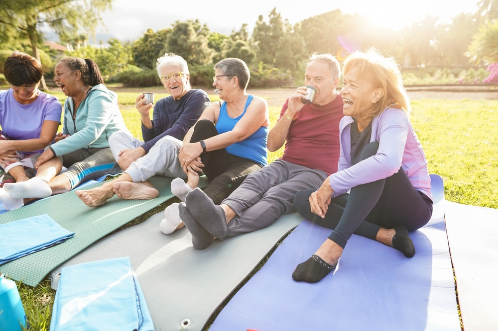 Seniors enjoying yoga outdoors on mats