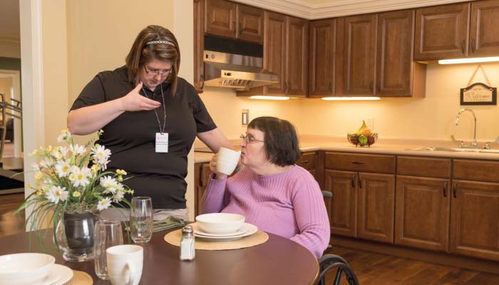 Staff assisting a resident in a dining area