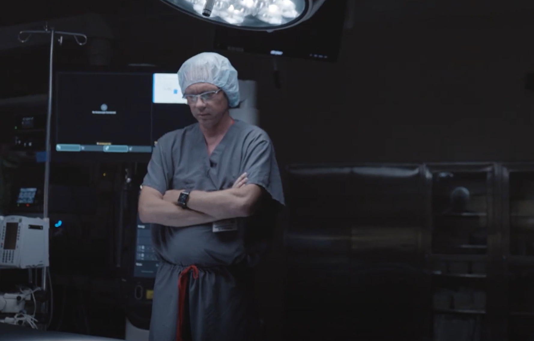 A healthcare professional in a dimly lit operating room