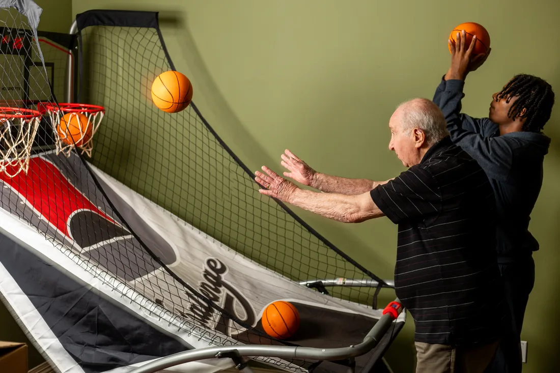 Residents enjoying a basketball shooting game indoors