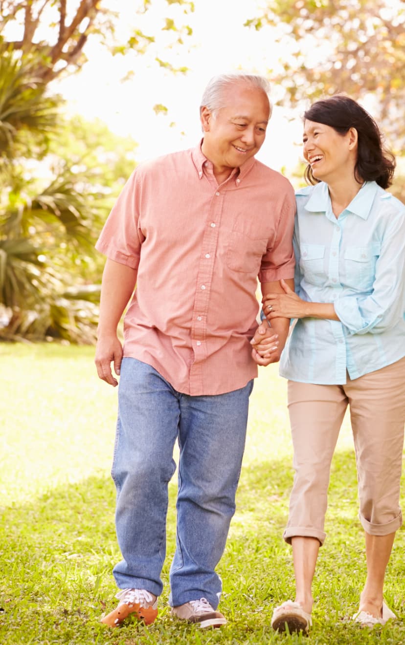 Couple walking hand in hand in a garden