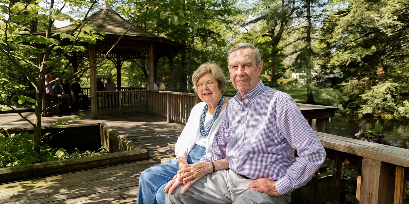 A couple sitting on a deck in a garden