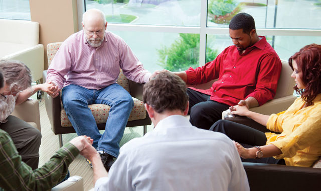 Residents and staff participating in a prayer circle