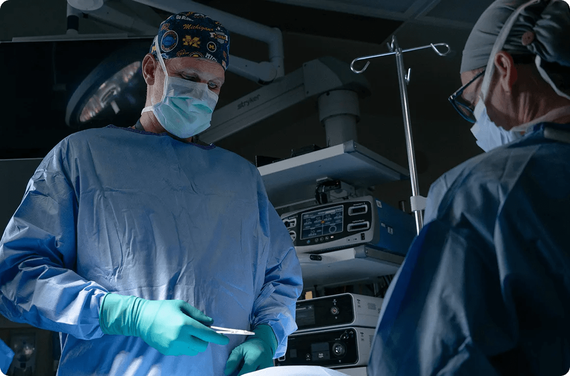Surgeons in a surgical setting wearing scrubs and masks