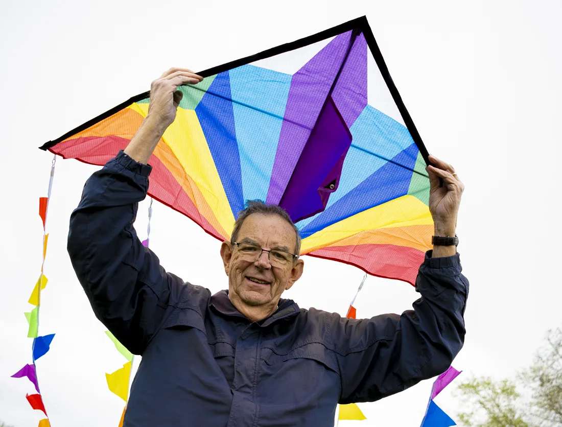 Senior man holding a colorful kite outdoors