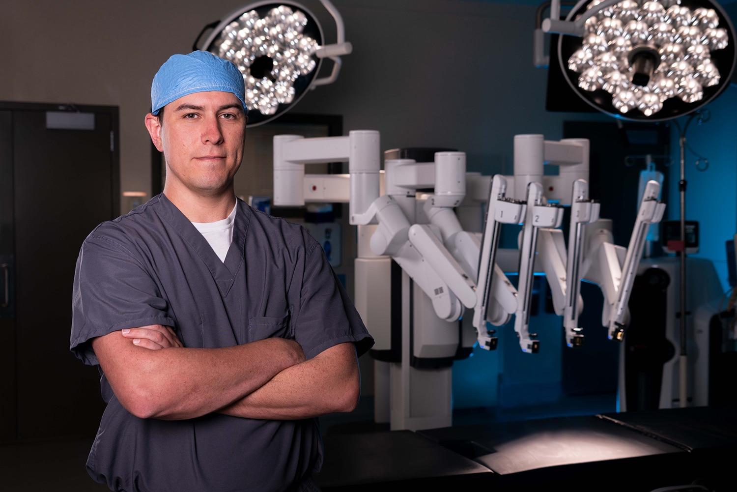 Surgeon in an operating room with robotic arms