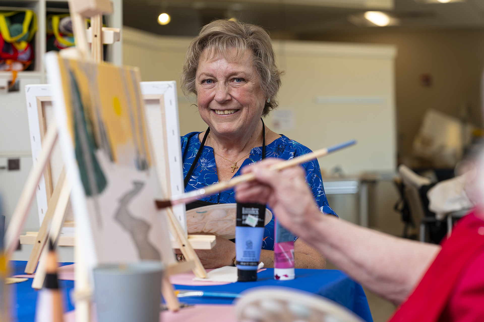 Resident painting during an art activity in a bright room
