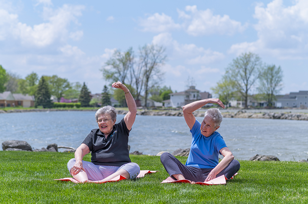 Residents participating in outdoor wellness activities by the water