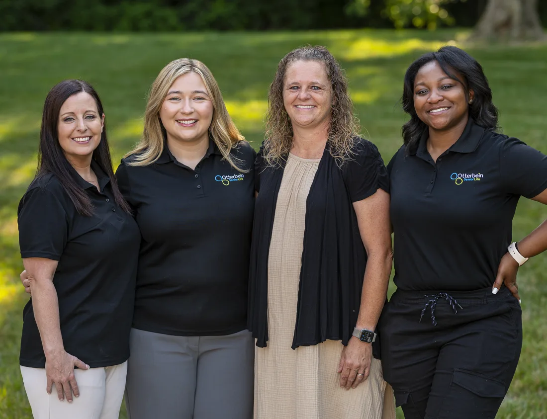 Staff posing outside in green space