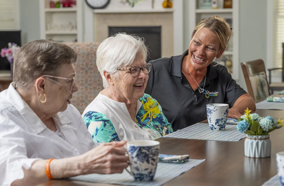 Residents enjoying a conversation with staff in a common area