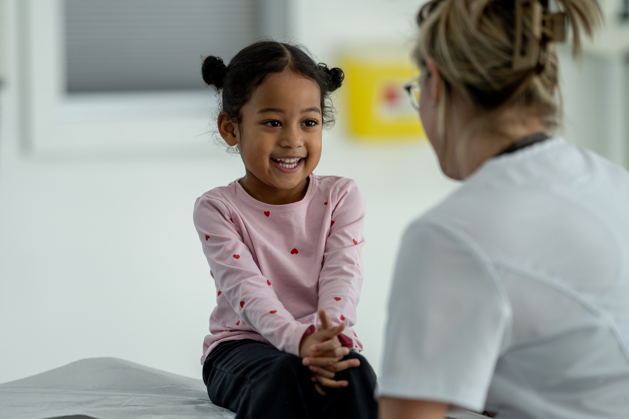 A young girl smiling with a healthcare professional.