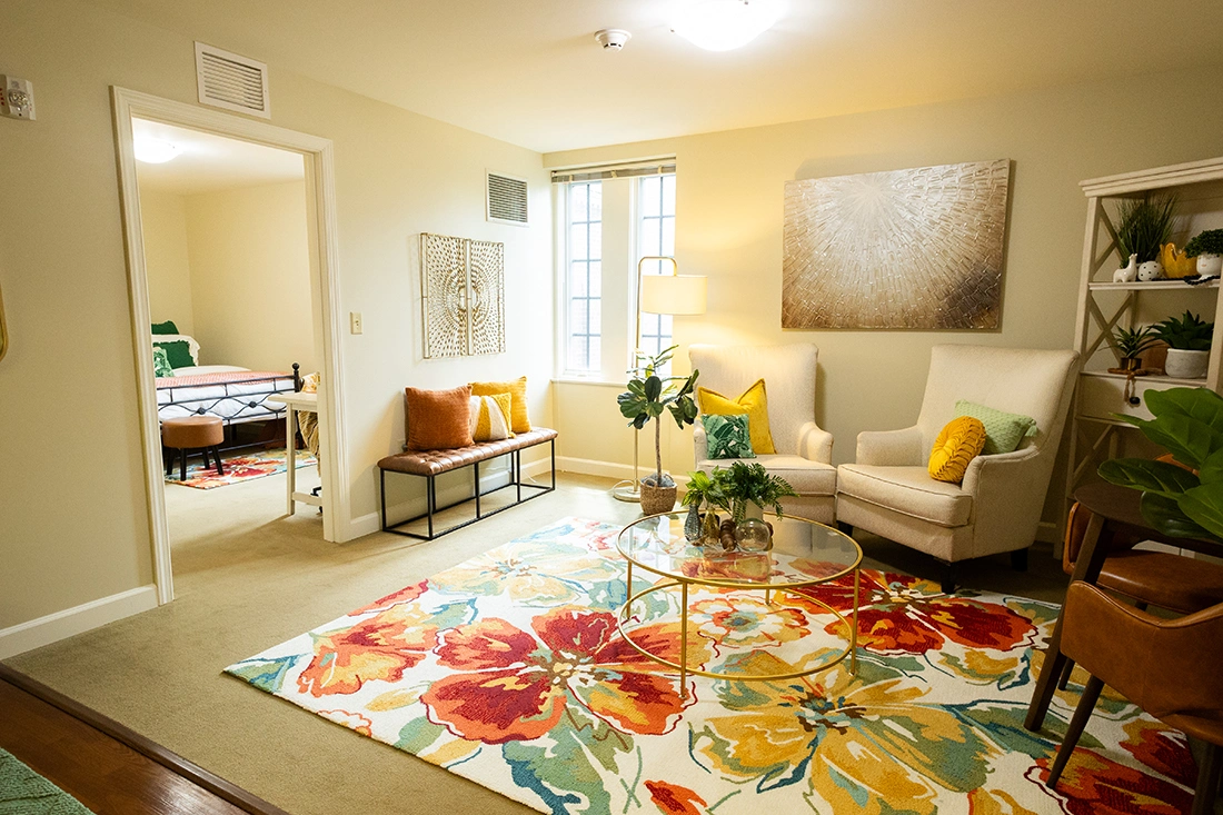 Bright common area with seating and colorful rug