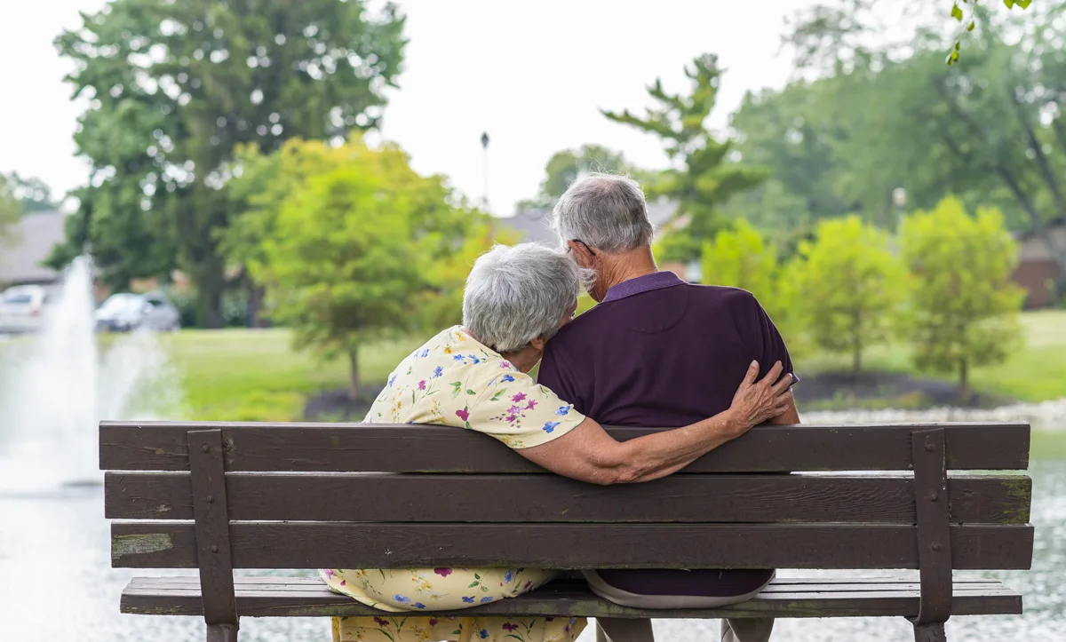Couple enjoying a moment on a bench by the water