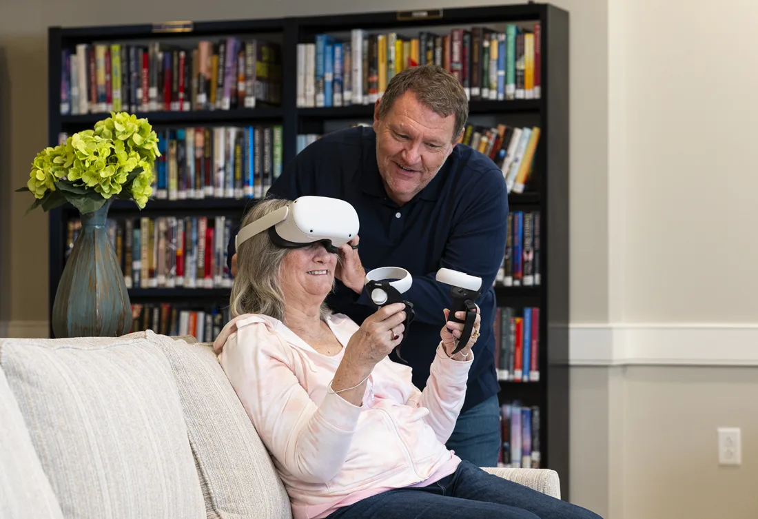 Resident using virtual reality headset with staff assistance