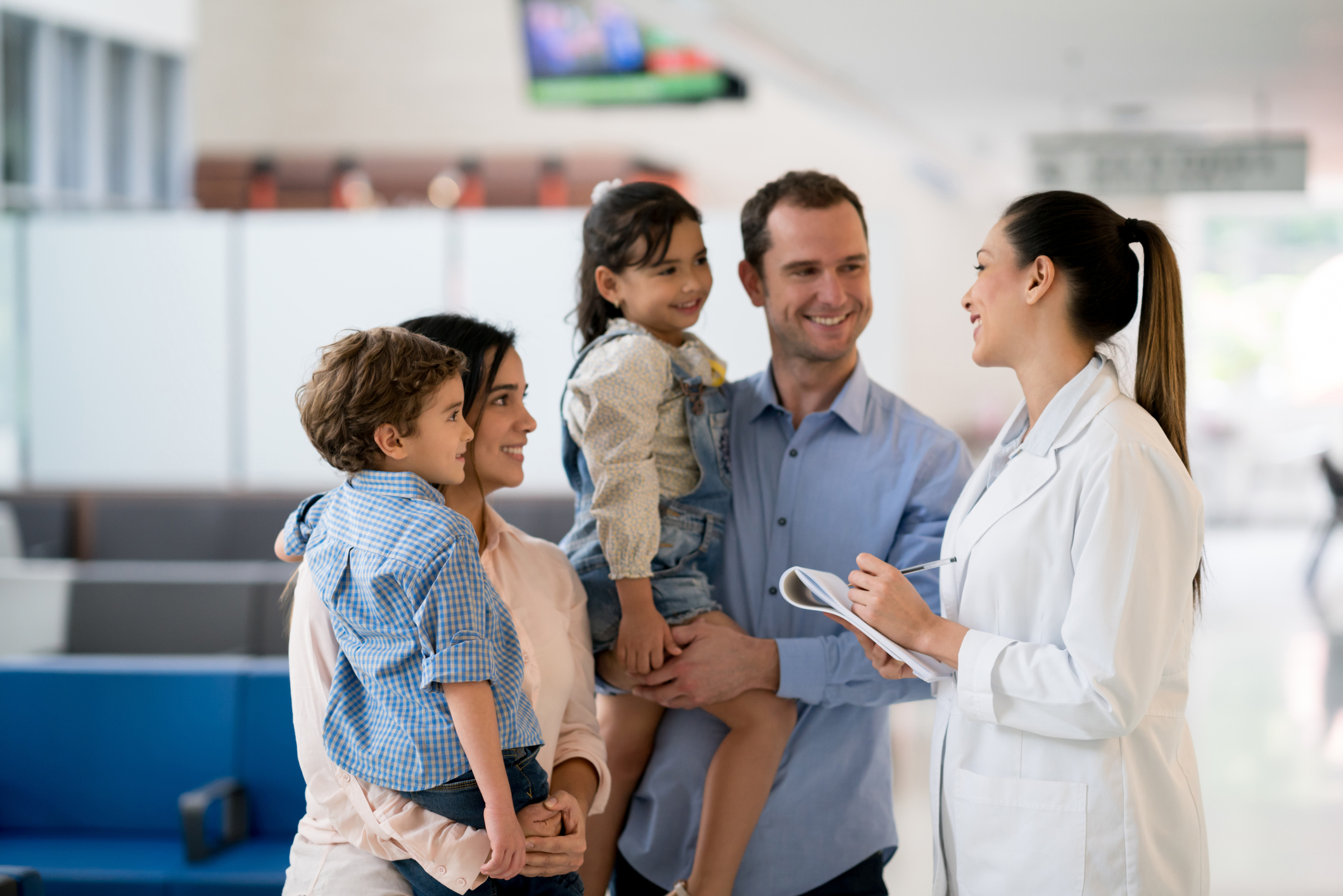 A family conversing with a healthcare provider in a well-lit facility lobby