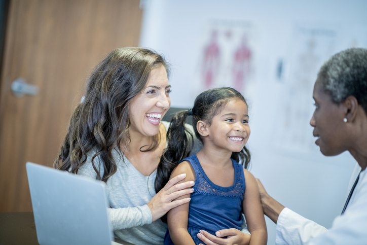 A woman and child smiling with a healthcare professional