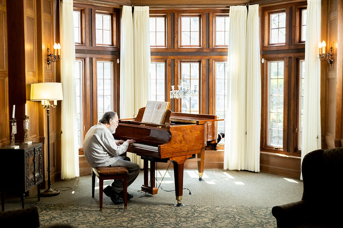 Resident playing piano in a bright lounge area