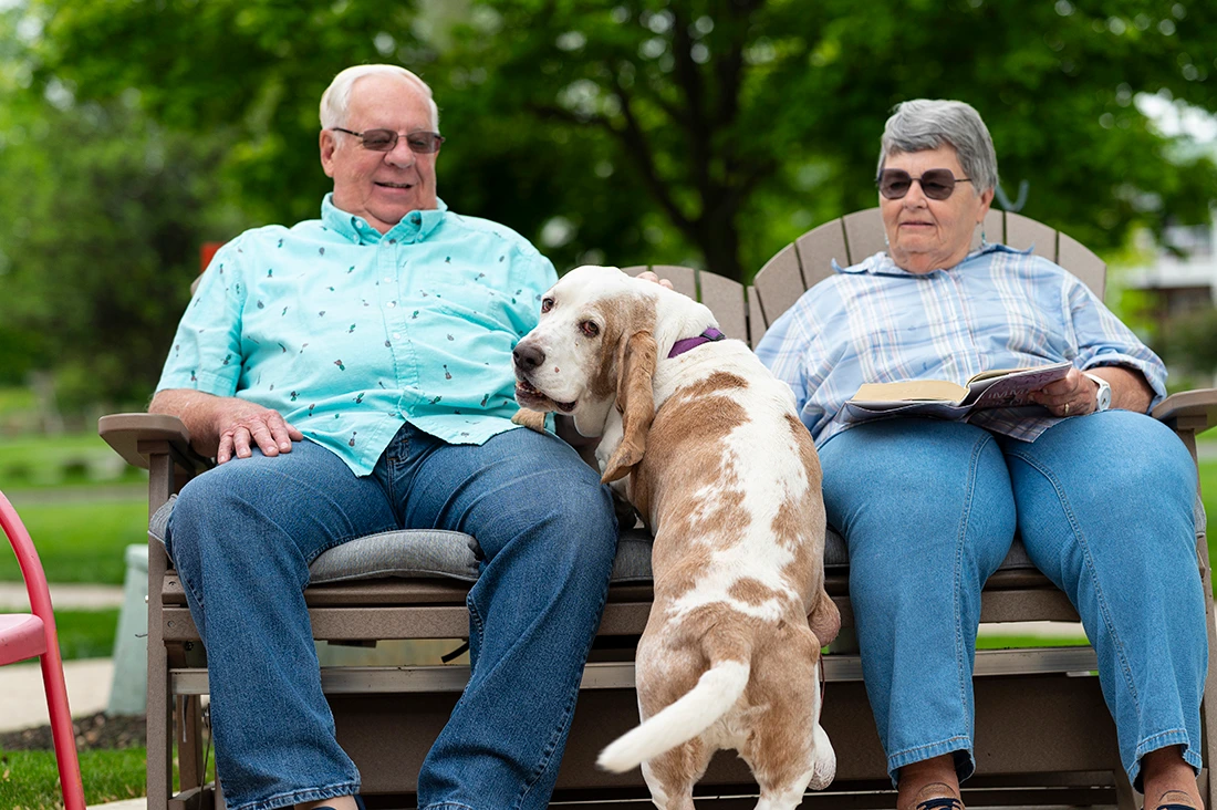 Two residents enjoying time outside with a dog