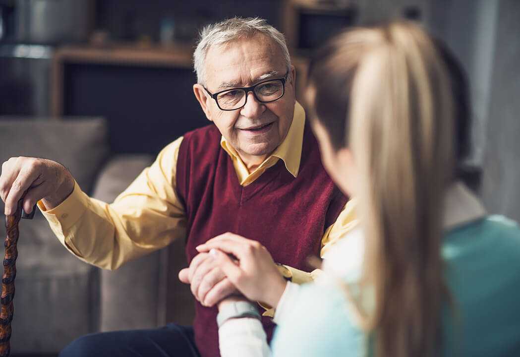 Senior resident talking with caregiver in a cozy setting