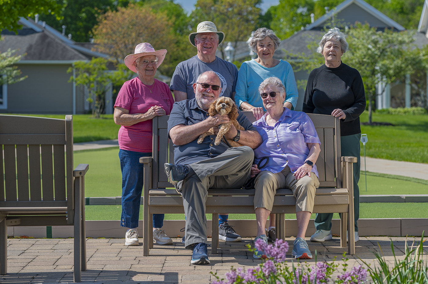 Residents and staff enjoying time outdoors with a small dog