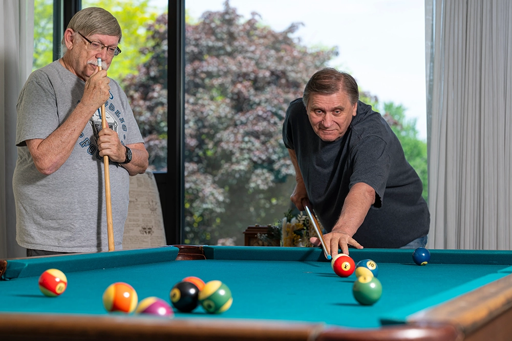 Residents playing pool in a common area