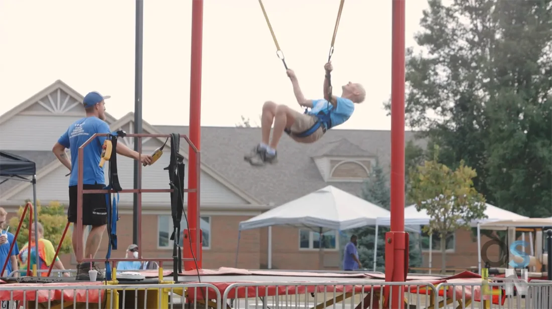 Resident enjoying a swing at an outdoor event