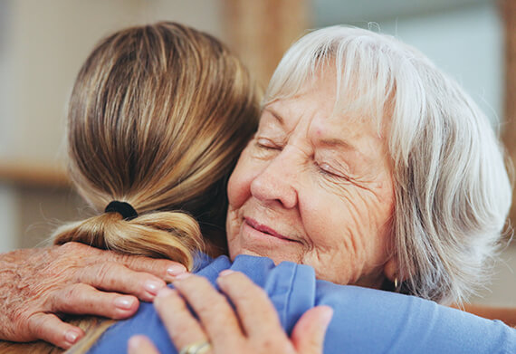 A caregiver and resident sharing a warm embrace