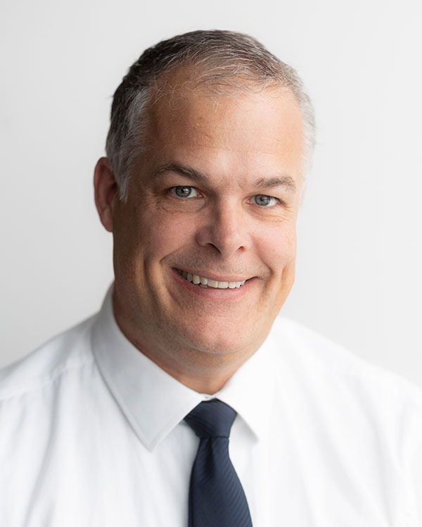 Portrait of a smiling man in a white shirt and tie