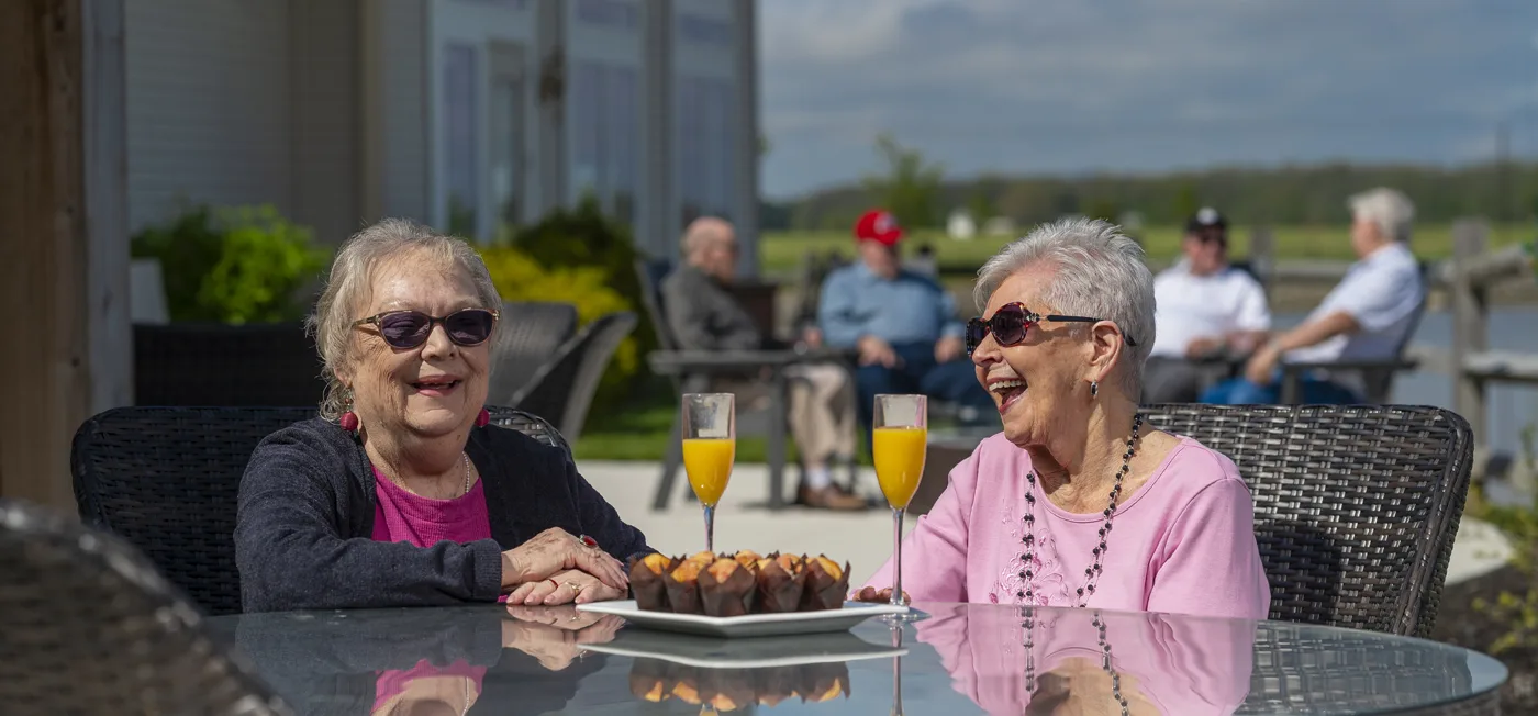 Two residents enjoying drinks and cupcakes outdoors