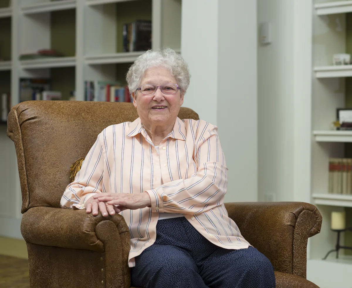 Resident sitting comfortably in a cozy chair