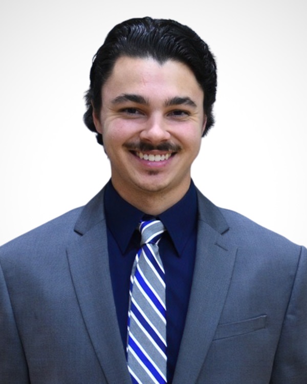 A man in a suit smiling at the camera