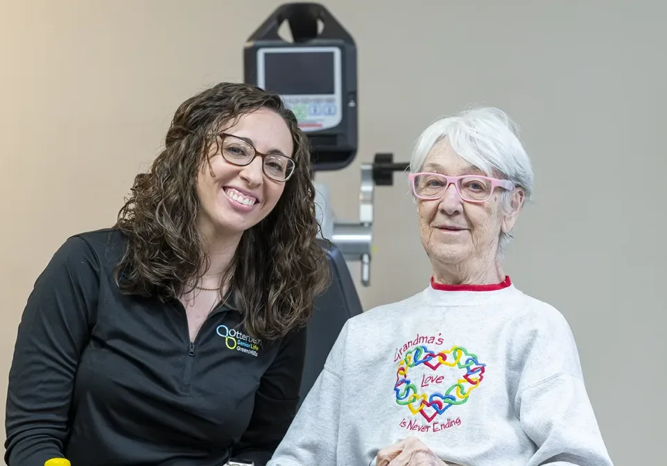 Resident and staff member smiling together in a facility