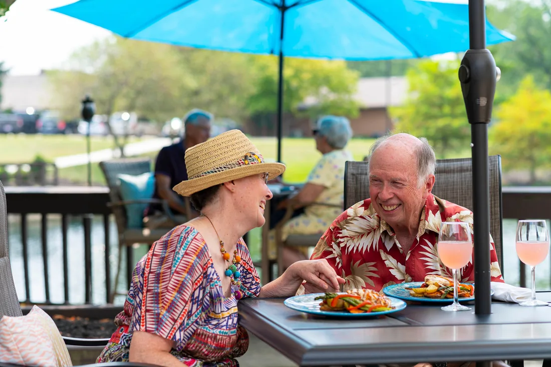 Residents enjoying a meal outdoors by the water