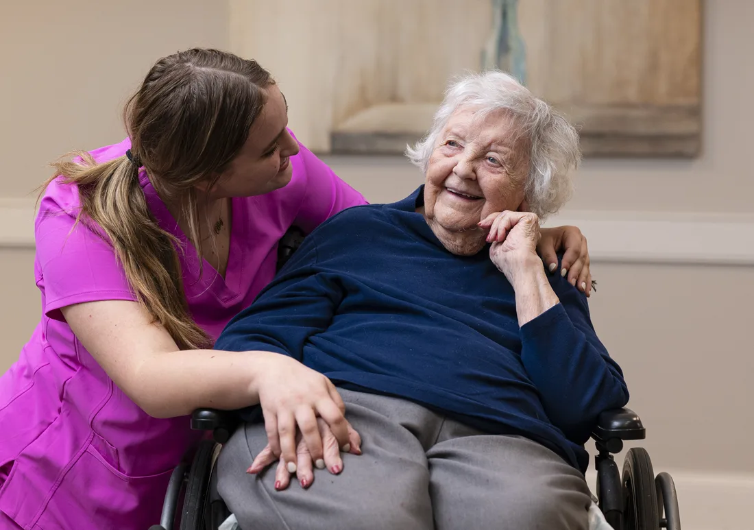 Staff interacting with a resident in a cozy interior setting